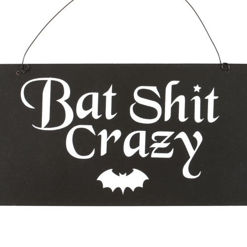 A quirky wooden sign reading "Bat Shit Crazy" for gothic decor, promoting individuality and dark humor in home spaces.