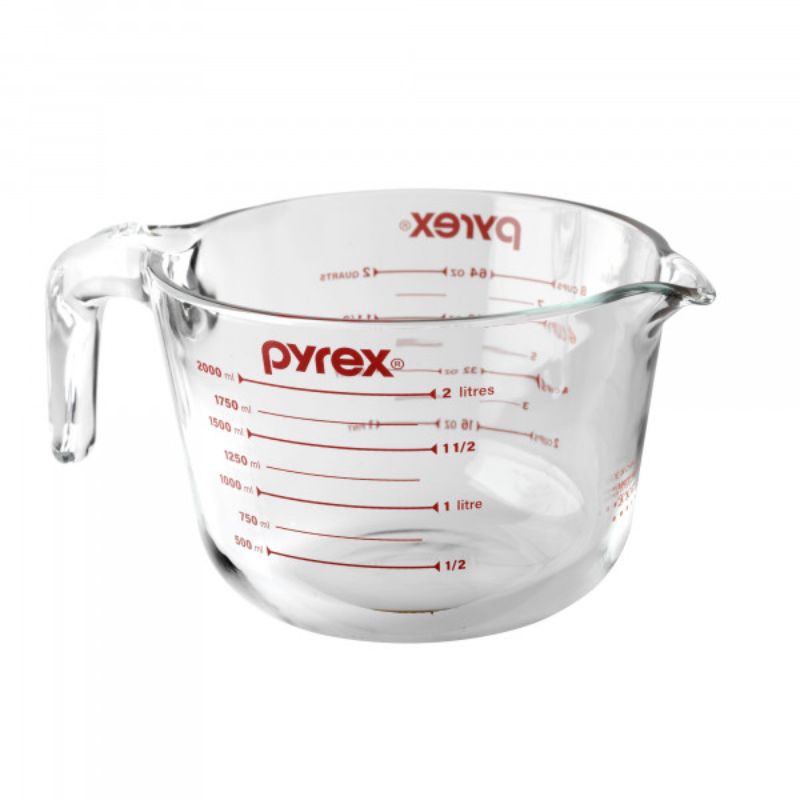 Clear Pyrex 8-cup measuring jug with ergonomic handle, precise measurement markers, and heat-proof glass for versatile kitchen use.