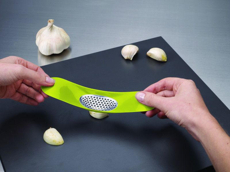 Joseph Joseph Garlic Rocker in green, an ergonomic tool for crushing garlic with ease, featuring a stylish design and easy cleanup.