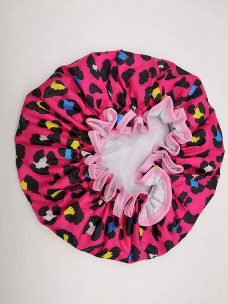 Stylish pink leopard print shower cap designed to keep hair dry during showers, made from durable waterproof materials.