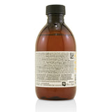 Golden-hued Davines Alchemic Shampoo for natural and colored hair, enhancing blonde tones with moisturizing ingredients.