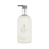 Molton Brown Refined White Mulberry Hand Lotion in a 300ml bottle, features clary sage, basil, and bergamot for hydrating luxury.