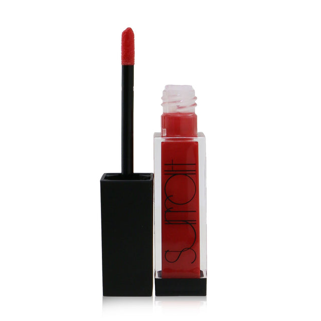 Bright coral lip gloss from Surratt Beauty, featuring a precise flocked tip for high-shine, non-sticky application.