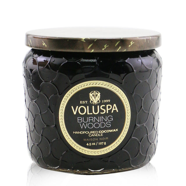 A petite jar candle with a luxurious coconut wax blend, featuring the warm scent of Burning Woods and an elegant glass container.