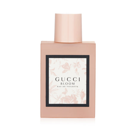 Gucci Bloom Eau De Toilette Spray in a frosted pink bottle, featuring floral notes for a fresh and radiant feminine scent.