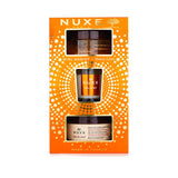 Nuxe Honey Lover Set: 3-piece skincare set with body scrub, oil balm, and candle for silky, nourished skin.