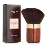 Guerlain Terracotta Powder Brush with soft bristles, beveled shape, and elegant lacquered wood base in a velvet suede pouch.