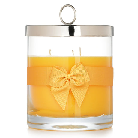 Luxury Rigaud scented candle #Tournesol, infused with mango and passion fruit, housed in a glass container with a bow tie.