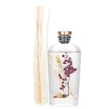 Botanica Berry Reed Diffuser in a transparent bottle, featuring vibrant botanicals and a soothing aroma for home decor.