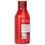 Redken Frizz Dismiss Conditioner in 300ml for frizzy hair, enriched with Babassu oil for moisture, shine, and smoothness.