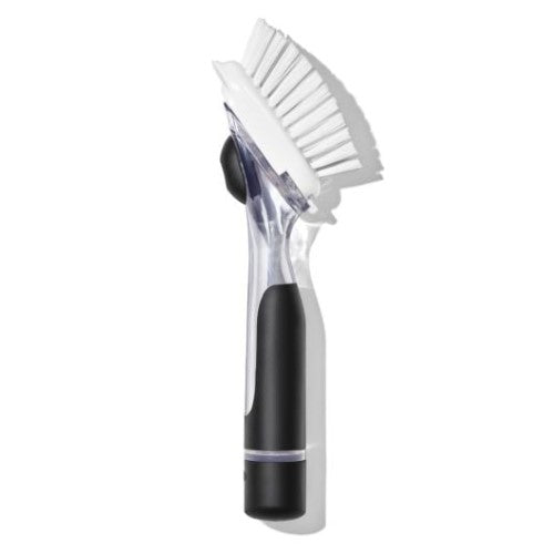 OXO Good Grips Soap Dispensing Dish Brush with ergonomic handle, soap reservoir, durable bristles, and built-in scraper for easy cleaning.