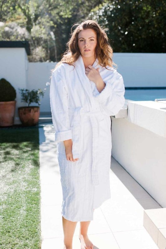 White luxury hotel bathrobe featuring stripe detailing, shawl collar, pockets, and waist tie, made from 100% certified cotton.