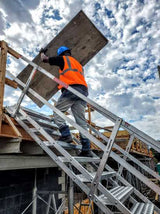 Adjustable aluminum safety stair with 18 self-leveling steps, designed for safe access between heights and easy storage.