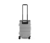 Sleek silver hardside carry-on luggage with aluminum frame, recessed wheels, and TSA locks for secure travel.