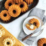 Mini Bundt pan creating six individual cakes, crafted from durable cast aluminum with an intricate design for delightful treats.