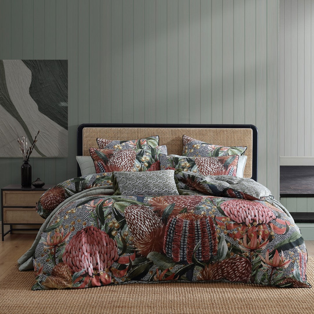 Vibrant Logan and Mason Barrabar Red quilt cover set with native foliage, Waratah flowers, and chic black piping, perfect for King beds.