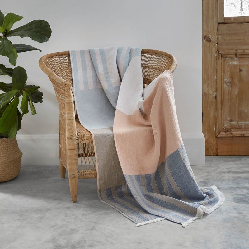 Soft jacquard throw in ecru, blue, and pink, featuring a natural fringe, made from 100% OEKO-TEX® cotton.