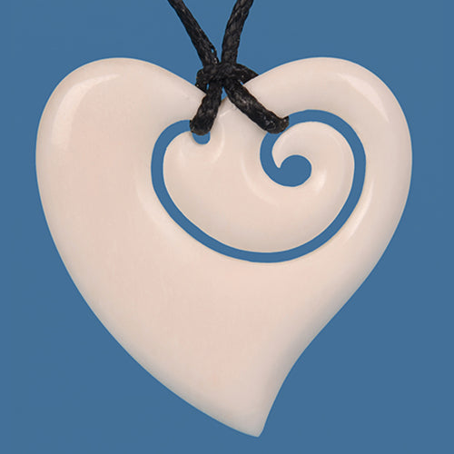 Stylized heart pendant carved from bone, featuring koru motifs, symbolizing love and growth on a black wax cord.