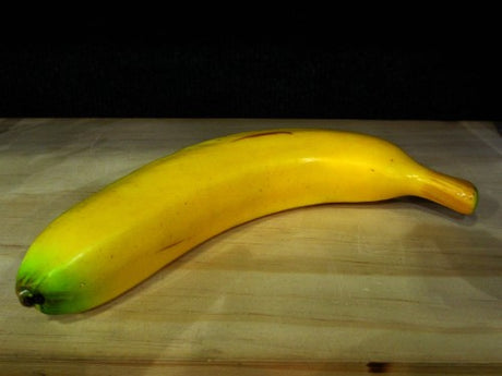 Realistic artificial banana made of polystyrene and plastic, ideal for home or showroom decoration, measuring 18cm x 6cm.