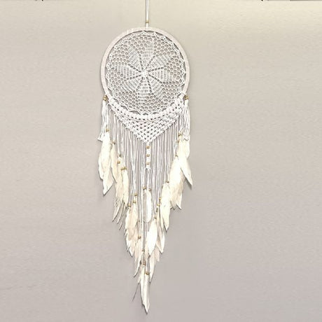 Handmade white crochet and macramé dreamcatcher star, adorned with beads and feathers, perfect for home decor.