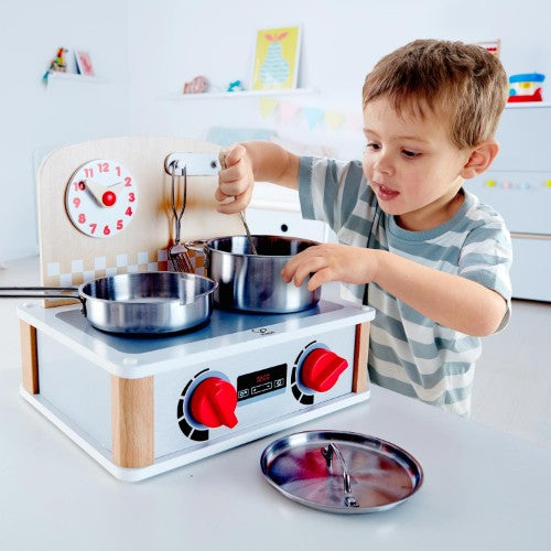 Hape 2-In-1 Kitchen & Grill Set with metal accessories, turnable knobs, and adjustable clock for role-play cooking fun.