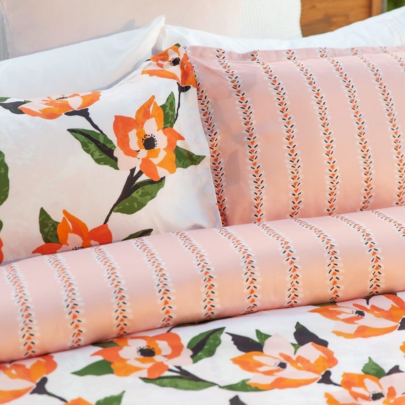 Hibiscus King duvet cover set with vibrant retro floral print in pinks and oranges, featuring reversible design and button closure.