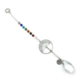 Suncatcher featuring Tree of Life design and clear quartz, promoting throat chakra healing and illuminating spaces beautifully.