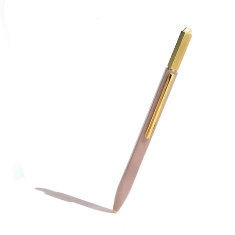 Glossy rose-colored copper ballpoint pen with engraved brass crown, offering a smooth writing experience and elegant design.