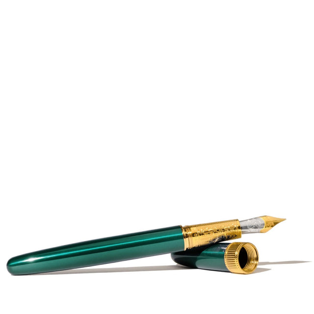 Elegant teal fountain pen with gold accents, engraved details, and a leather sleeve, perfect for creative writing experiences.