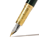 Elegant emerald green fountain pen featuring a two-tone nib and brass grip, perfect for luxurious writing experiences.