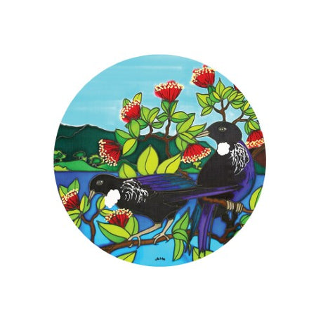 Vibrant ceramic trivet featuring Tui artwork, doubles as wall hanging; ideal for hot dishes and decor with cork backing.