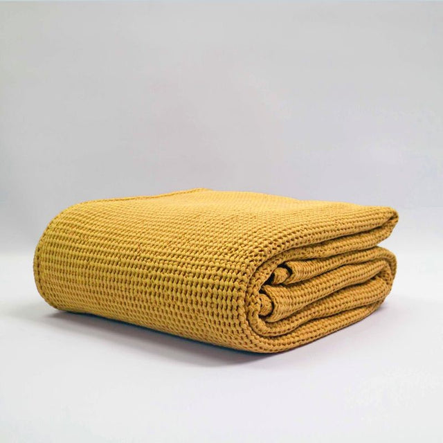 Large turmeric stonewashed blanket by Baksana, featuring a bouncy waffle texture, made from 100% OEKO-TEX® certified cotton.