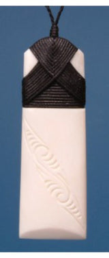 Engraved large toki pendant in bone, symbolizing strength and peace, on adjustable cord, packaged in flax kete.