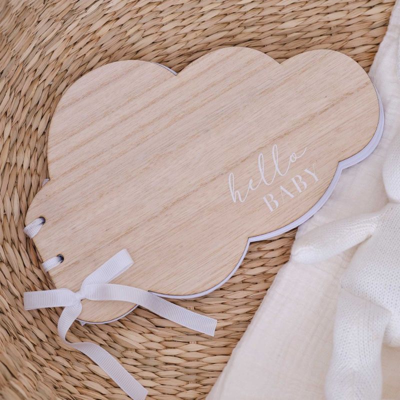 Wooden baby shower guest book shaped like a cloud, adorned with a white ribbon, measuring 17cm x 26cm.