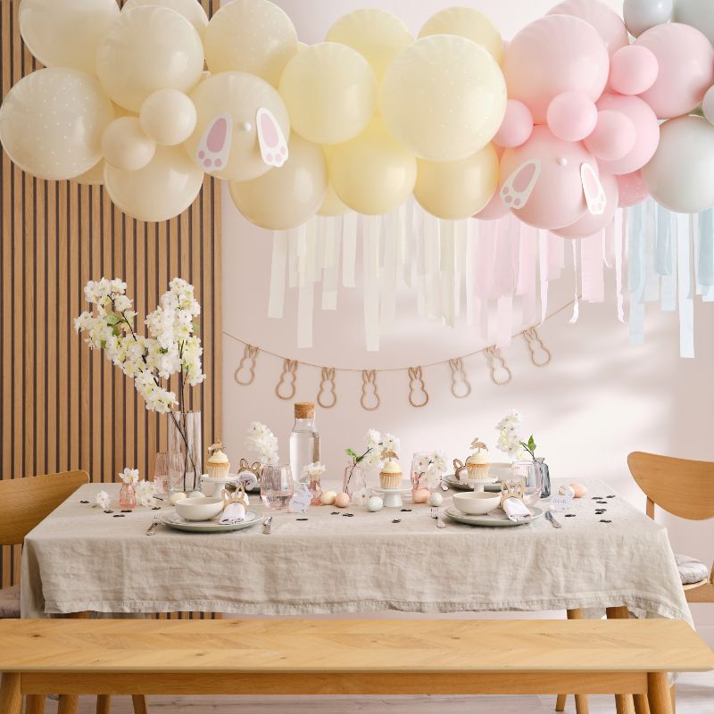 Colorful Easter balloon arch kit featuring pastel balloons, bunny feet decor, and streamers for a festive celebration backdrop.