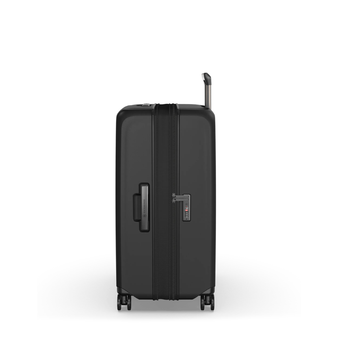 Hardside black suitcase with expansion system, elastic straps, and dual-caster wheels for easy maneuverability.