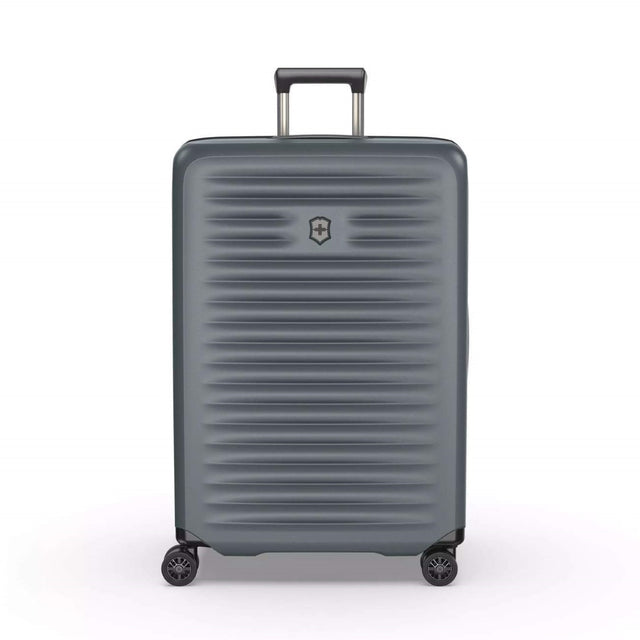 Durable green hardside suitcase with expansion system, X-shaped straps, and dual-caster wheels for effortless travel.