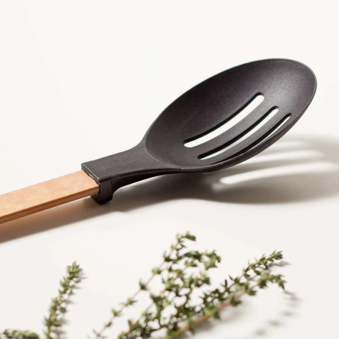 Natural wooden slotted spoon from Epicurean, 33.5cm with ergonomic design, heat resistant head, and built-in kickstand.