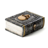 Gothic trinket box shaped like a book, featuring intricate skull embellishments, perfect for jewelry and collectibles.