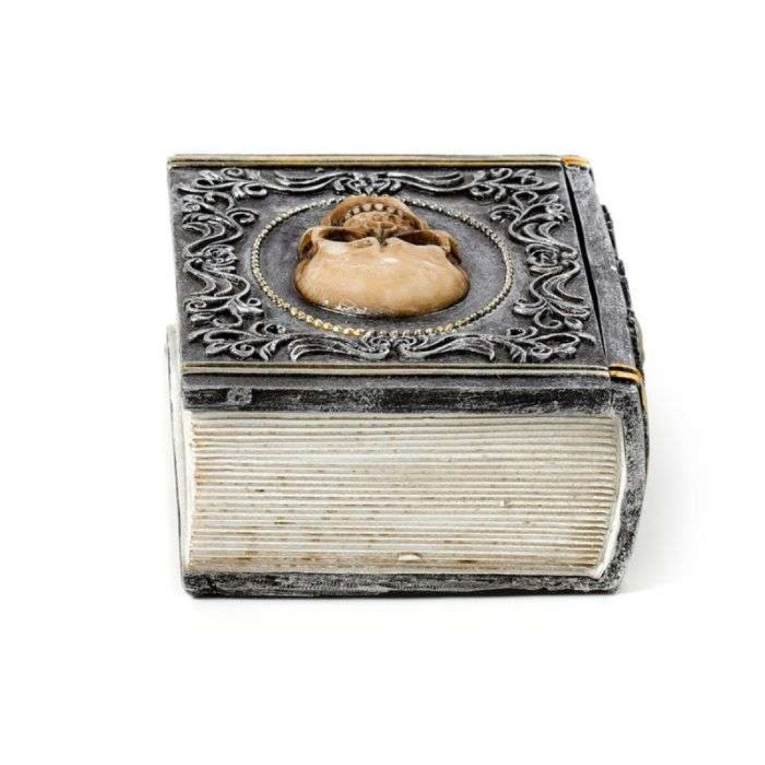 Skull embellished trinket box shaped like a book, perfect for storing jewelry and collectibles with gothic charm.