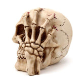 Gruesome 16cm skull head ornament with a skeleton claw hand, perfect for Halloween decor and gothic collections.