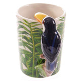 Ceramic mug with vibrant toucan design and jungle-shaped handle, perfect for coffee and tea lovers.