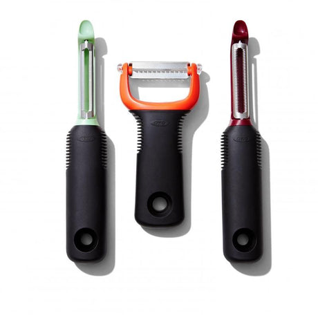 Three OXO Good Grips peelers: swivel, serrated, and julienne, with non-slip handles and sharp stainless steel blades for easy peeling.