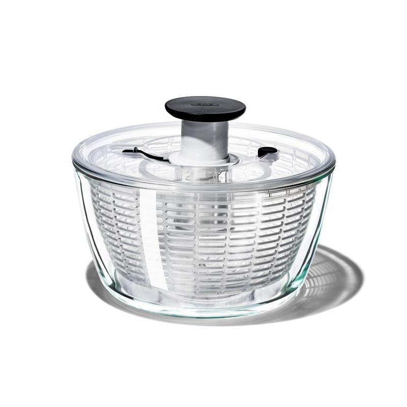 Elegant glass salad spinner with non-slip knob for easy greens drying and rinsing, featuring a removable colander and compact storage.