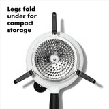 Compact and ergonomic OXO Good Grips Food Mill with stainless steel bowl, three grinding discs, and foldable legs for easy storage.