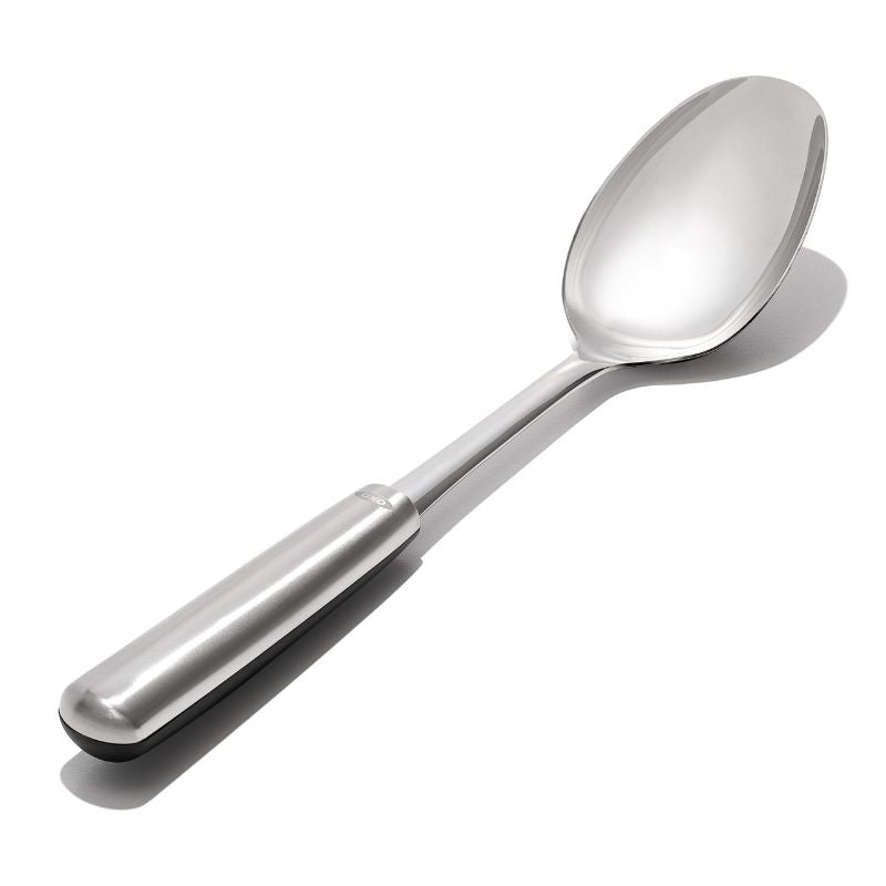 OXO Steel Cooking Spoon in stainless steel, featuring an ergonomic handle and non-slip fins, perfect for stirring and serving.