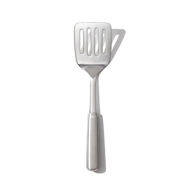 Stainless steel OXO Cooking Turner with a non-slip handle, perfect for flipping and serving delicate foods in the kitchen.