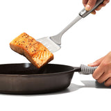 OXO STEEL Cooking Turner with sturdy stainless steel head and non-slip handle, perfect for flipping and serving food.