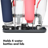 OXO Good Grips Water Bottle Drying Rack holding four bottles and lids with straw holders, designed for sanitary and efficient drying.