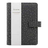 Personal size Filofax organiser in charcoal with gold accents, featuring a patterned rose quartz interior and multiple pockets.